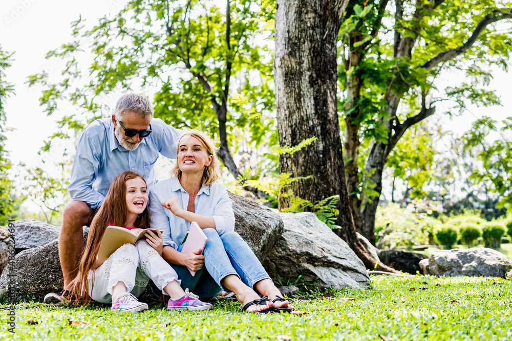 Happy family reading book relax in weekend holiday lifestyle park outdoor nature background. Happy family reading book relax in weekend holiday lifestyle park outdoor nature background.