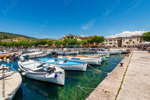 Small port of Lake Garda  Lago di Garda  with many boats moored  and cityscape of Garda  famous tourist resort in Verona province  Veneto  Italy  southern Europe.