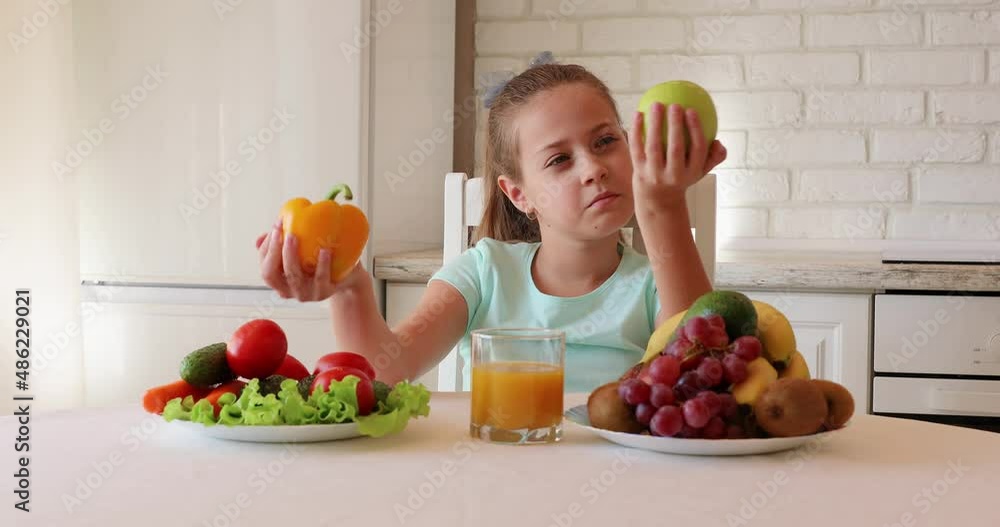 little girl wants to eat vegetables and fruits. the child enjoys fresh fruits and vegetables. girl showing thumbs up. copy space little girl wants to eat vegetables and fruits. the child enjoys fresh fruits and vegetables. girl showing thumbs up. copy space