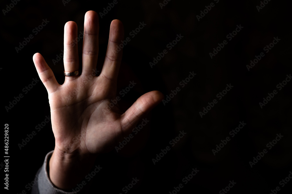 female palm aimed at the camera on a black background. Place for your text. female palm aimed at the camera on a black background. Place for your text.