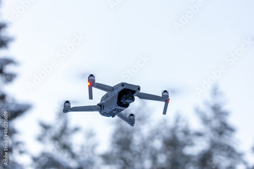 Drone flying snowy tree top background
