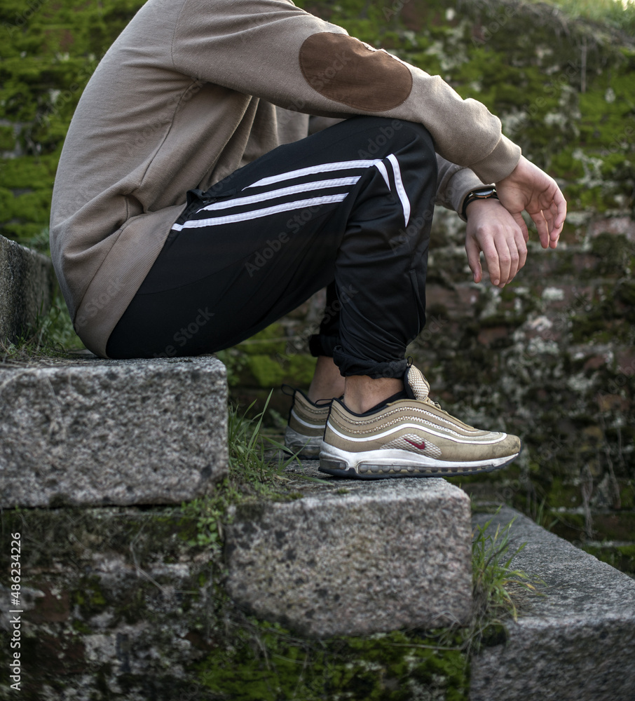 young man wearing Nike Air Max 97 Gold shoes in the street Stock Photo |  Adobe Stock