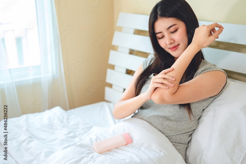 asian woman use lotion hands cream moisture and white moisturize lotion on bed in bedroom, therapy beauty, skin care concept.