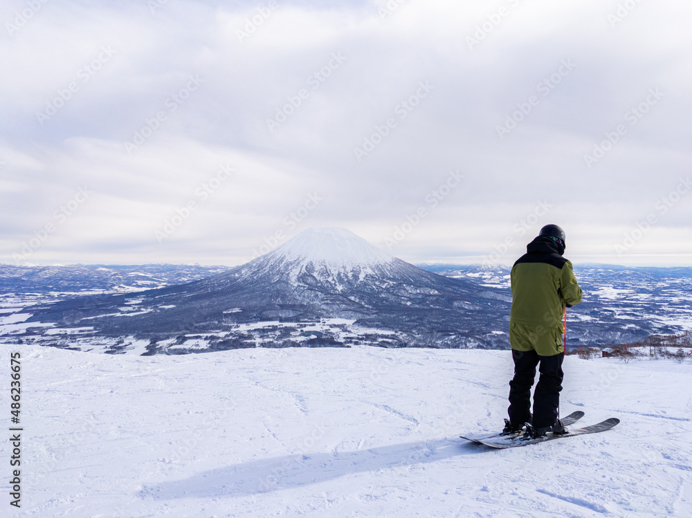 Skier and snowy volcano (Niseko, Hokkaido, Japan)
