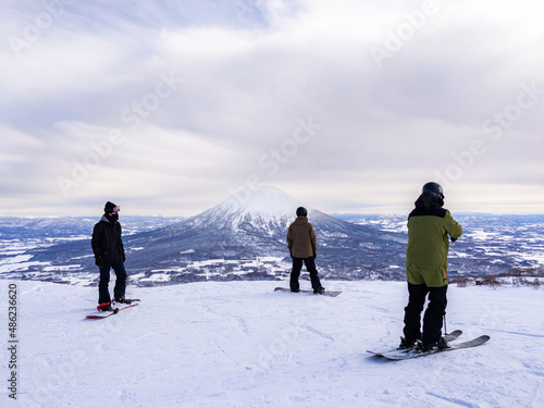Skier and snowboarders with snowy volcano (Niseko, Hokkaido, Japan)