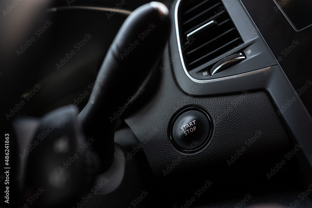 Start stop button on a modern car. Keyless system. Black plastic interior with chrome details