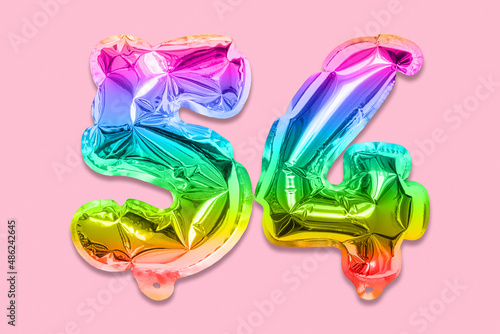 Rainbow foil balloon number, digit fifty four on a pink background. Birthday greeting card with inscription 54. Top view. Numerical digit. Celebration event, template. photo