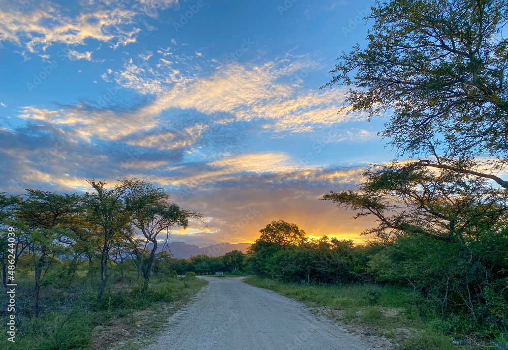 Beautiful dirt road leading into the sunset with blue sky, Lowveld South Africa