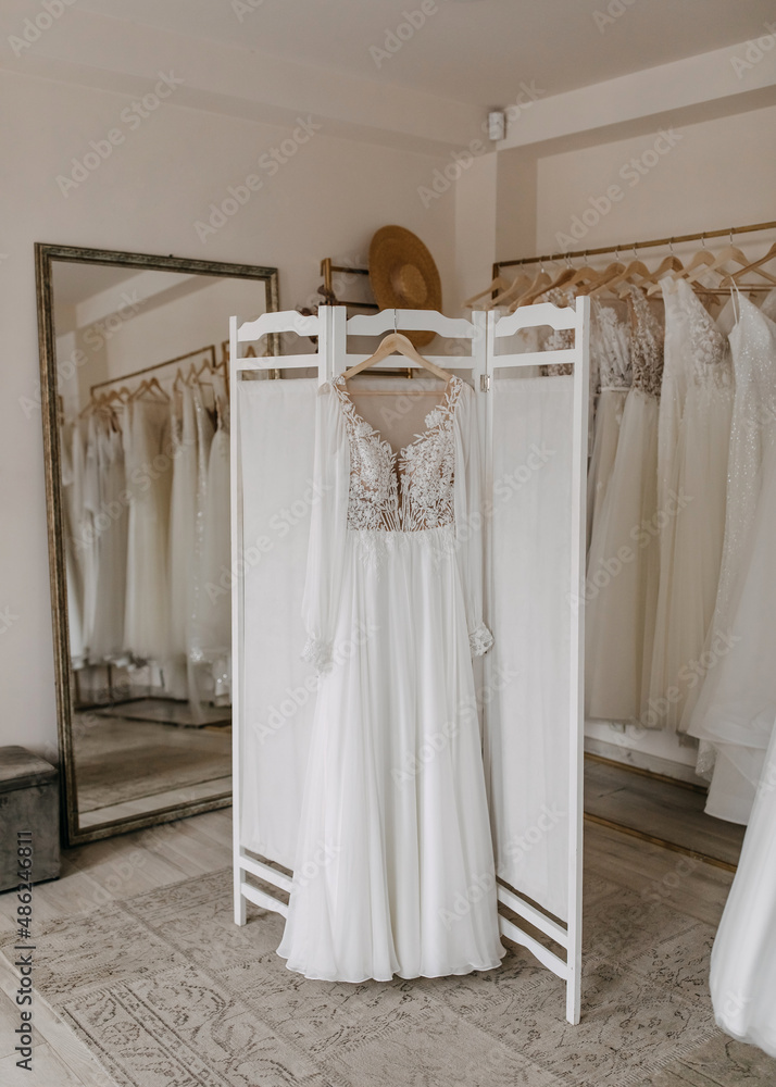 Bohemian style wedding dress hanging at a bridal showroom.