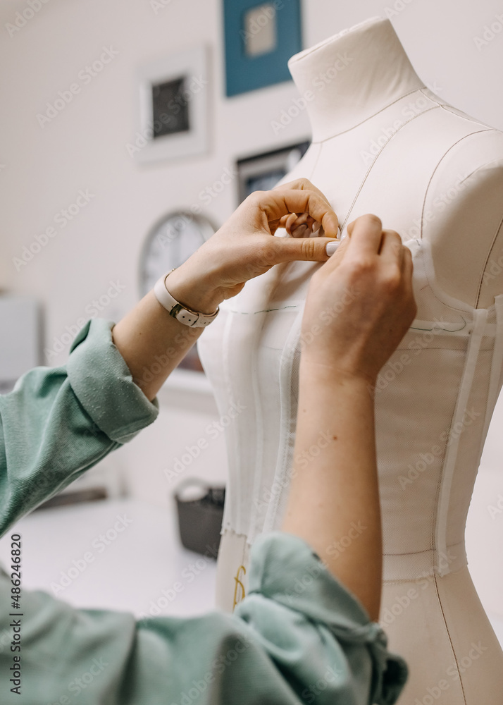 Foto de Work process of a tailor in her studio. Hands sewing bridal