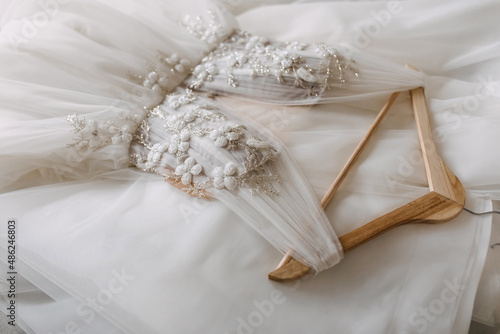 Closeup of a handmade wedding dress with flower and crystals embroidery.