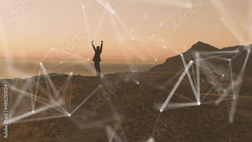 The idea of motivating and inspiring a person who is in a network of responsibilities. A man in a suit enjoys the rising sun standing on top