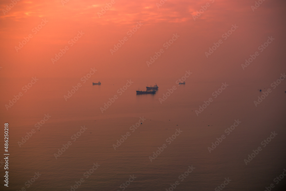 Fototapeta premium Panoramic nature background (mountains, sea, trees, twilight lights in the sky, waterfront communities), naturally blurred through the wind, seen on tourist spots or scenic spots