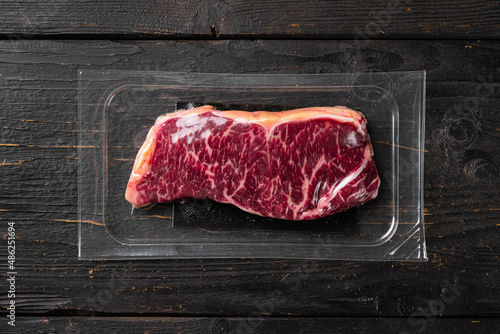 New-York steak pack, on black wooden table background, top view flat lay