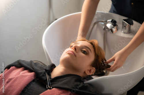 woman client person having a process to making treatment a hair with hairdresser in beauty salon