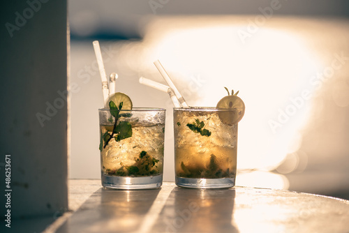 Two mojito cocktails against the sunset light on the beach