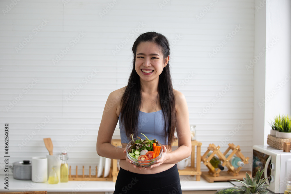 young Asian woman cooking vegetable healthy food and eating or drinking in home kitchen young Asian woman cooking vegetable healthy food and eating or drinking in home kitchen