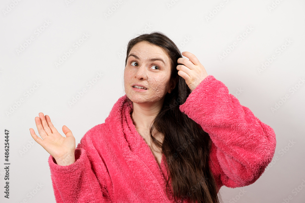 A beautiful young woman applied a scrub or mask to her face, facial skin care, skin cleansing A beautiful young woman applied a scrub or mask to her face, facial skin care, skin cleansing