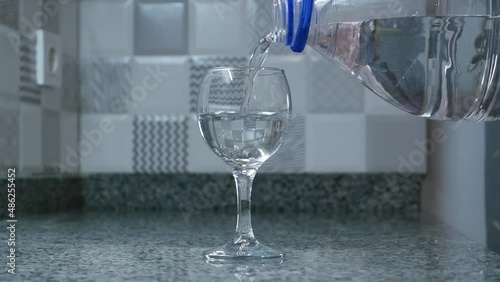 pouring water from a plastic bottle into a glass.