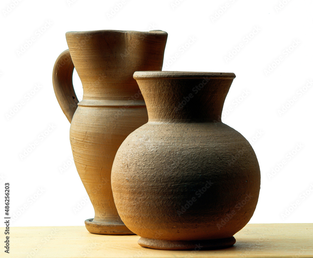 Two little handcrafted clay jars on white background