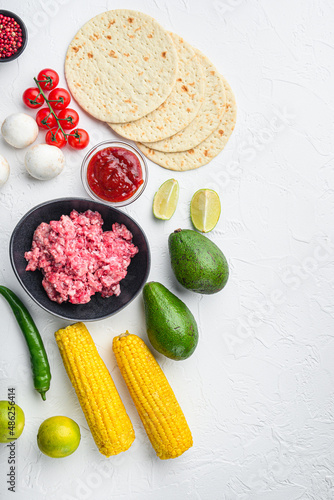 Mexican tacos with vegetables and meat. Ingredient for cooking, Top view over white background with space for text.