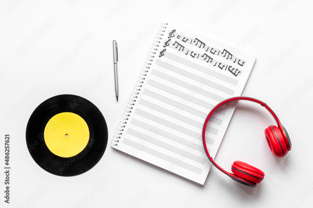 Music sheets with musical notes and headphones, top view