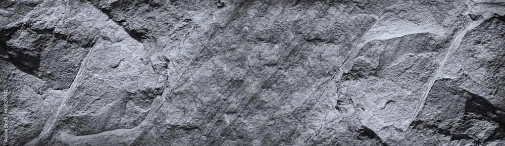 Black white rock texture. Mountain surface. Close-up. Gray granite stone background with copy space for design. Wide banner. Panoramic. Black white rock texture. Mountain surface. Close-up. Gray granite stone background with copy space for design. Wide banner. Panoramic.