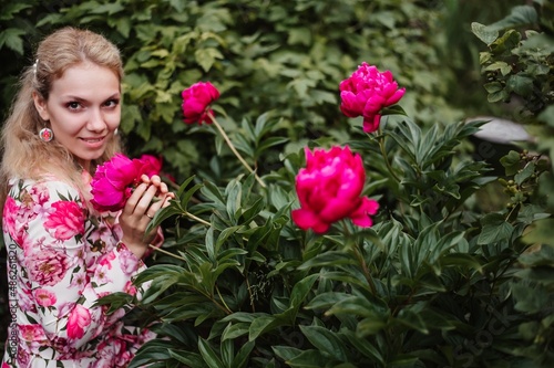 A Girl Smelling Of Pink Peony Flowers.