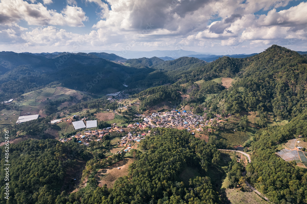 Aerial view of local village in the valley among tropical rainforest at countryside