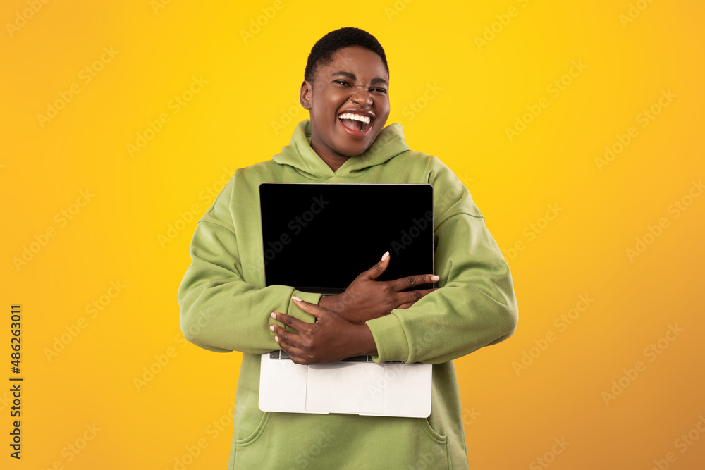 Joyful Oversized Black Lady Embracing Laptop Computer Over Yellow Background