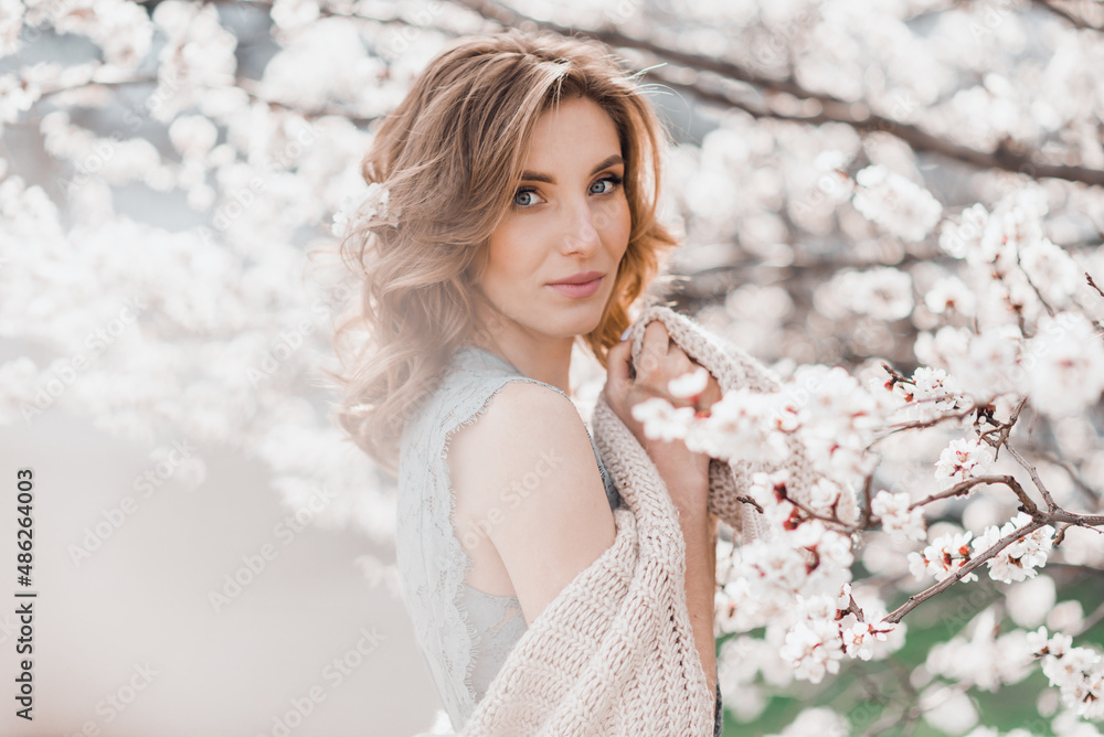 Portrait of pretty blond girl posing against the spring blooming trees in the garden. Portrait of pretty blond girl posing against the spring blooming trees in the garden.