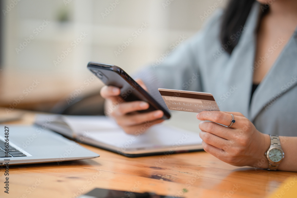 Close up hands of a woman holding credit card shopping on the website. Close up hands of a woman holding credit card shopping on the website.