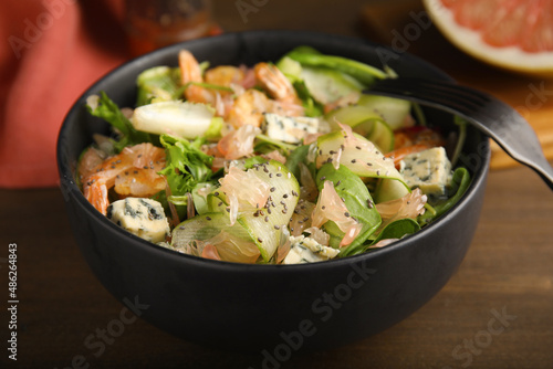 Delicious pomelo salad with shrimps served on wooden table, closeup