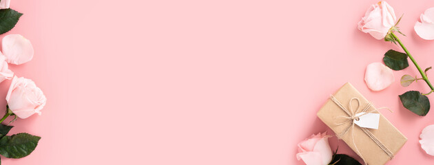 Valentine's Day design concept background with pink rose flower and gift on pink background.