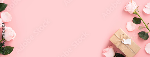 Valentine's Day design concept background with pink rose flower and gift on pink background.