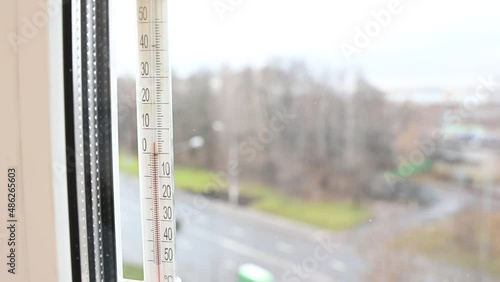 A view at window thermometer which indicates plus five degree celsius scale, spring thaw outdoor photo