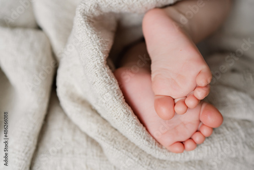 Close up photo of little child barefoot feet on knitted blanket. copy space