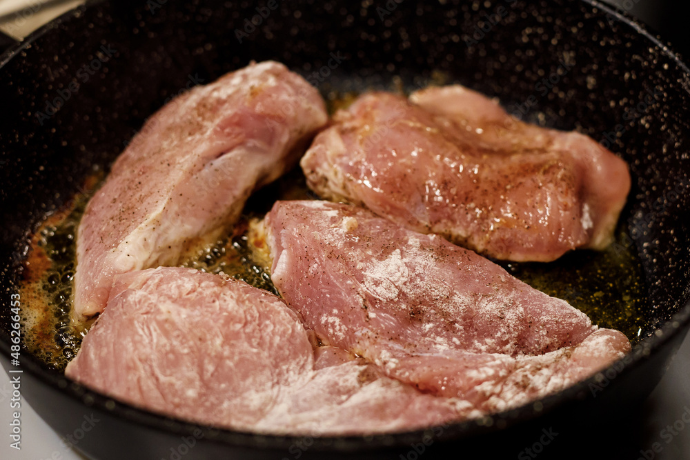 Turkey fillet frying in a pan. Turkey fillet frying in a pan.