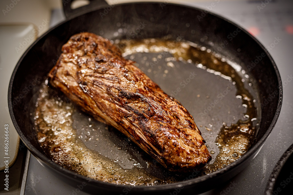 Fototapeta premium A piece of beef is fried in a pan.