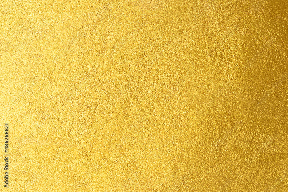 Gold wall texture background. Yellow shiny gold foil paint on wall sheet with gloss light reflection Gold wall texture background. Yellow shiny gold foil paint on wall sheet with gloss light reflection