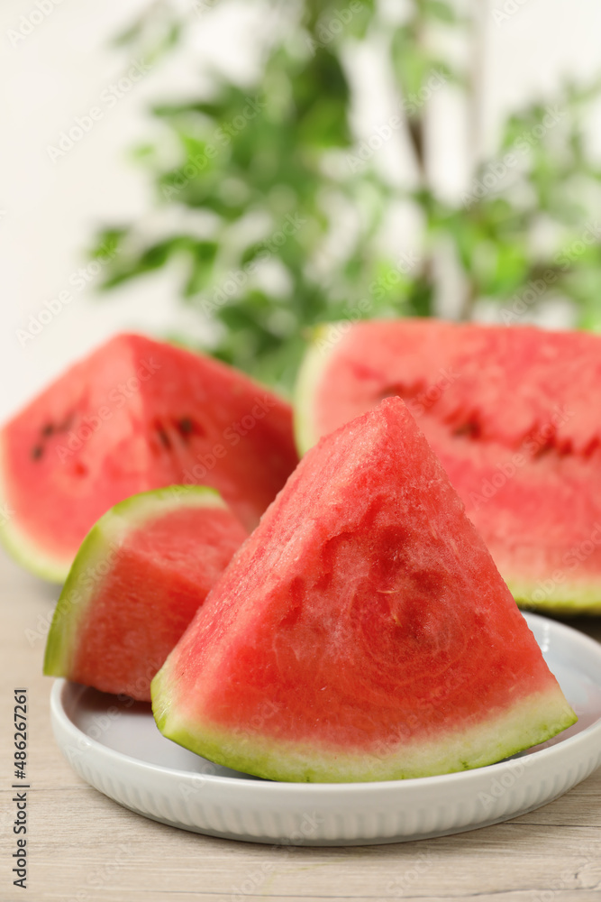Slices of tasty ripe watermelon on light wooden table, space for text