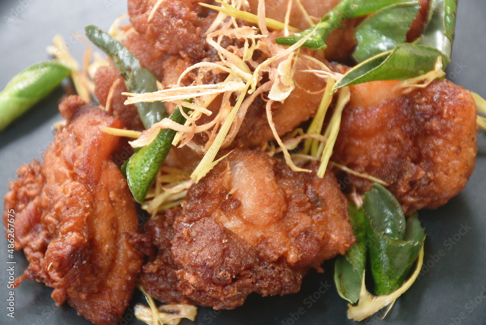 spicy fried chicken with chili and lemon leaf on dish spicy fried chicken with chili and lemon leaf on dish