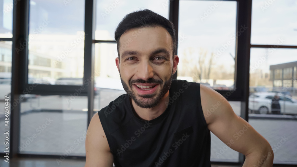 Cheerful sportsman looking at camera in gym Cheerful sportsman looking at camera in gym