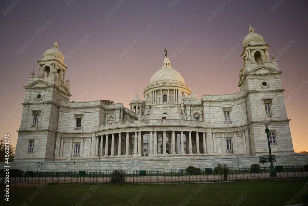 Obraz premium The Queen Victoria Memorial, against the backdrop of the sunset sky, in the city of Kolkata