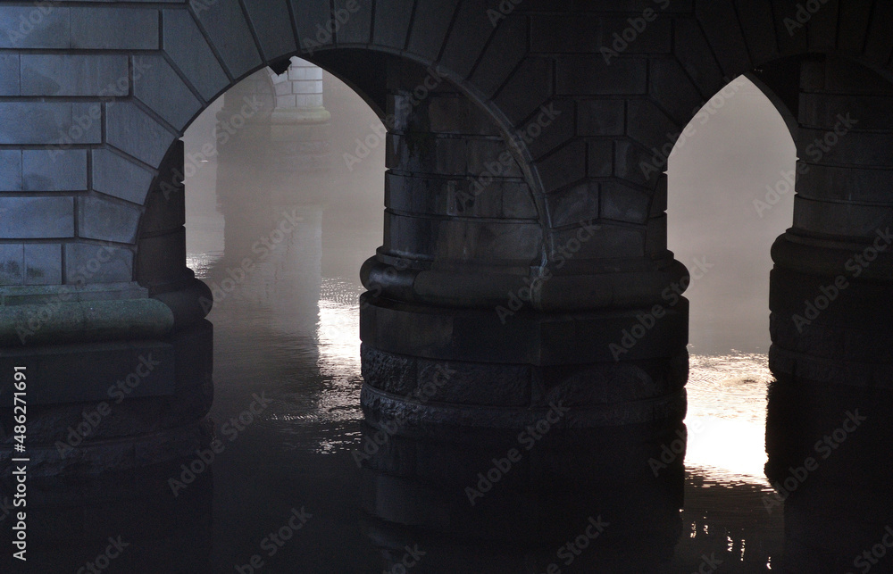 Stone Bridge Supports Reflected in River Waters 
