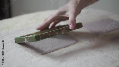 A woman holding a frame for making paper sheets from recycled paper. Selective focus. Household hobby, paper recycling. The concept of zero waste, recycling, ecology