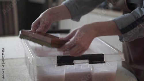 A woman holding a frame for making paper sheets from recycled paper. Selective focus. Household hobby, paper recycling. The concept of zero waste, recycling, ecology