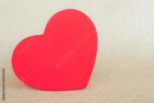 Beige background of natural material texture burlap with heart-shaped paper box.