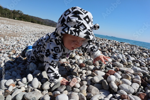 cute adorable little child on the pebble beach of Cirali, Turkey