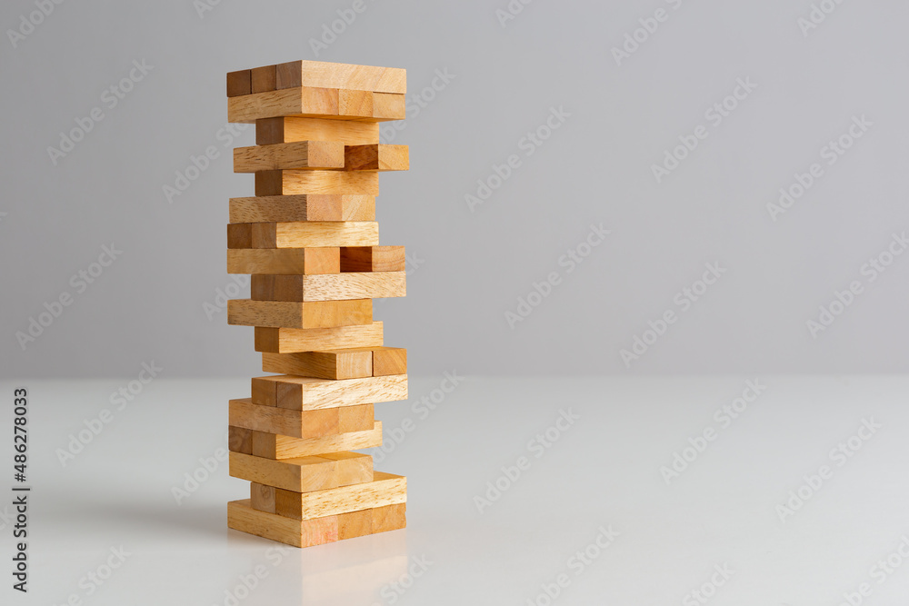 Tower wooden block, builds tower from wooden blocks on grey background.